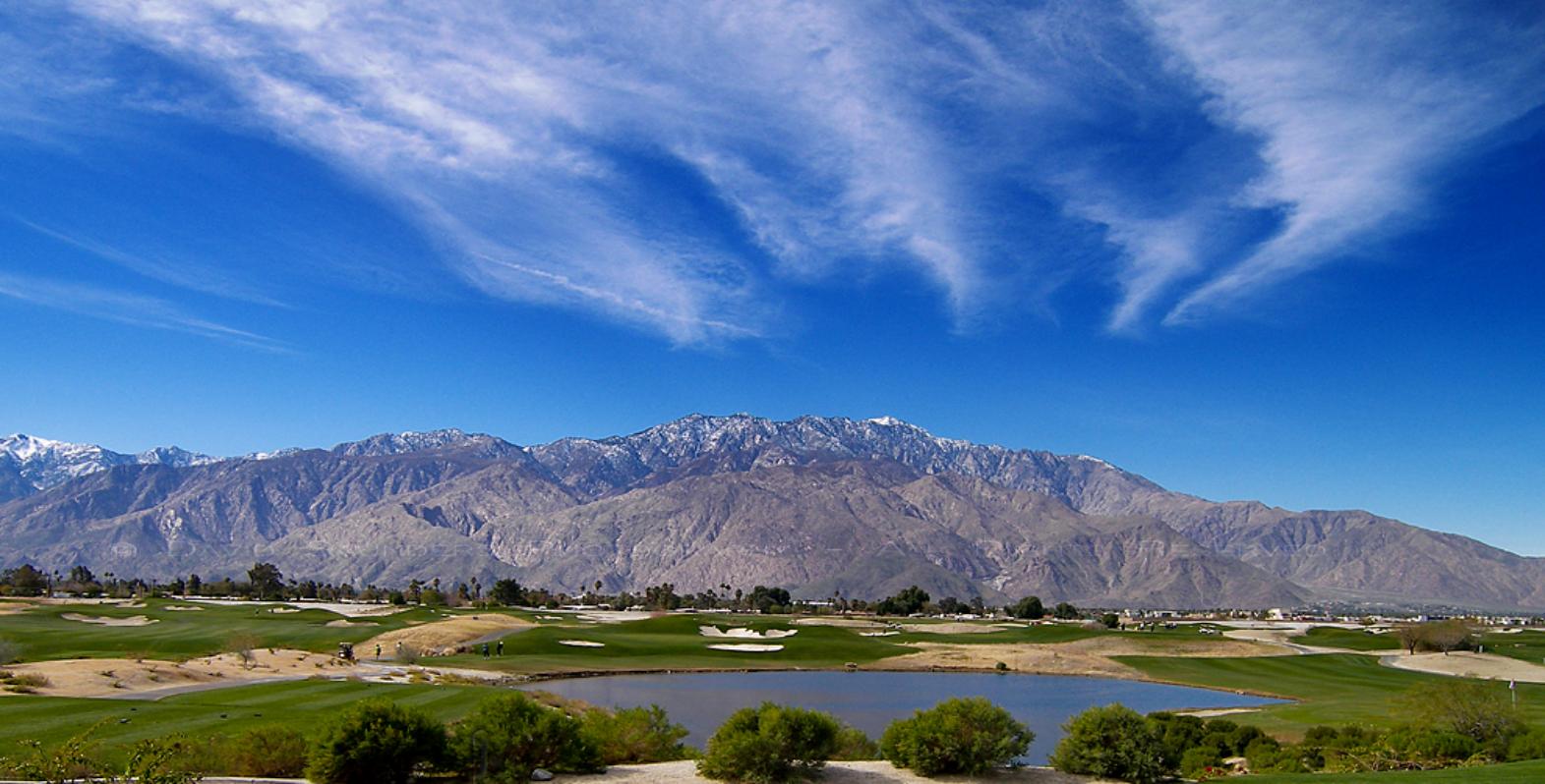 Scenic view of golf course with mountains in the background
